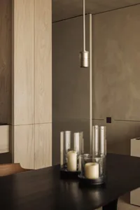 Industrial-style interior with metal table, pendant light, and candles.