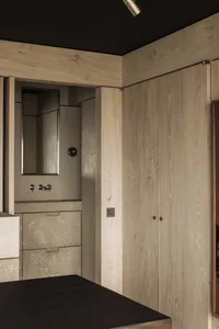 Modern bathroom featuring concrete walls and wooden cabinetry.
