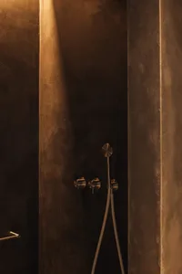 Concrete shower area with metallic fixtures in a modern bathroom interior