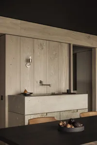Modern kitchen with minimalist design featuring concrete countertops and cabinets.