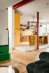 Modern kitchen with vibrant yellow tiles, wooden cabinets, and minimalist design.
