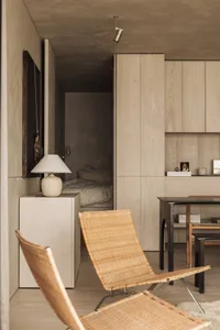 A modern minimalist living room with wooden furniture and a sandy beige color palette.