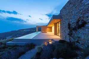 Modern residential pool deck with stone and concrete materials.