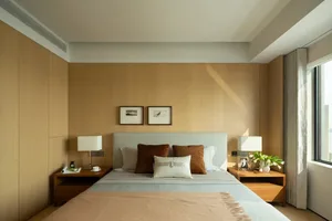 A minimalist bedroom with a bed, nightstands, and framed pictures on the wall.