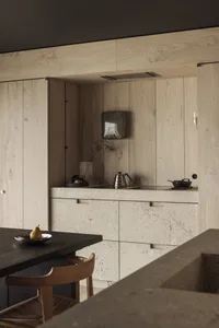 Minimalist kitchen with stone countertop and cabinets, featuring modern design elements.