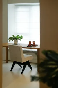Minimalist living room with wooden flooring, a beige couch, and a white coffee table.