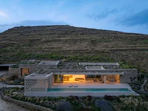 Modern residential house with concrete and stone materials, featuring a swimming pool and rooftop garden.