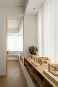 Modern living room with a wooden floor, glass windows, and upholstered furniture.