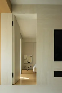 Modern minimalist bedroom with neutral tones, featuring sleek furniture and a minimalist art piece on the wall.