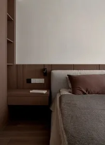 A minimalist bedroom featuring a wooden bed frame and headboard, with a simple and clean design.