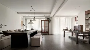 A modern minimalist living room with concrete and wood furniture, large windows, and a low-slung sofa.