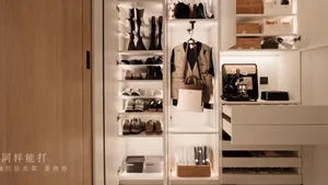 Modern closet storage system featuring sleek, white cabinets, open shelving for shoes, and built-in lighting.