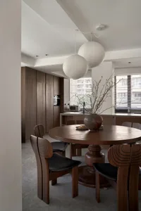 Modern kitchen with wooden furniture and a plant on the dining table.
