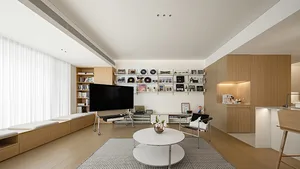 A modern living room with minimalist wooden shelves, hardwood flooring, and a round white coffee table.