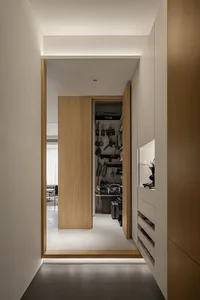 A modern, minimalist wardrobe storage area featuring wood, metal, and glass elements.