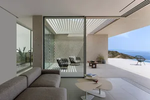 Contemporary residential interior with concrete blend walls and large floor-to-ceiling windows.