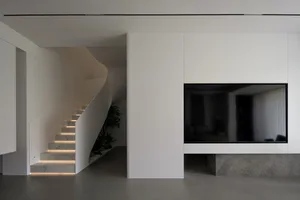 A contemporary minimalist living room with a concrete floor and modern design elements.