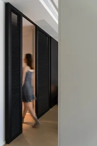 A modern apartment featuring black sliding doors with wooden accents.