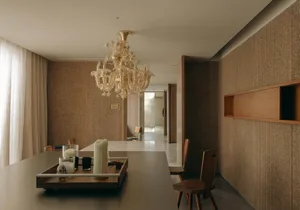 Interior design of a modern dining room featuring a wooden chandelier and furniture.