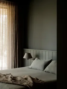 A minimalist bedroom with soft, neutral fabrics and textiles.