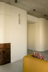 Modern minimalist interior with metallic elements and curved surfaces.