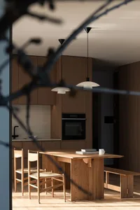 A minimalist kitchen featuring wooden cabinets and a dining table with chairs.