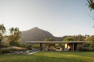 A modern house with a minimalist interior, featuring a concrete design and a view of the surrounding landscape.