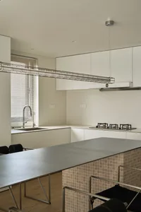 A modern kitchen featuring a sleek metal countertop with minimalist design elements.