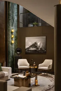 Modern living room with marble floor, metallic chairs, and fabric seating.