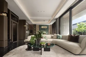 Modern living room with white marble flooring and a large, light-colored sofa.