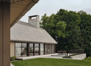 A modern residential house with a wooden exterior and large windows.