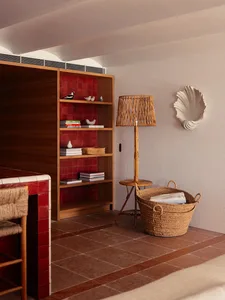 A cozy living room with wooden shelves and red tiles.