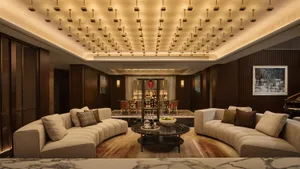 A luxurious hotel reception room featuring modern leather sofas, marble accents, and a sophisticated lighting design.