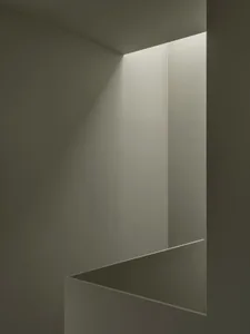 A minimalist interior space featuring concrete walls and flooring.