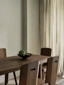 Modern dining room featuring solid wood furniture and a single artichoke.