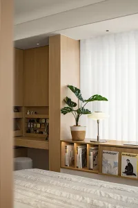 A minimalist bedroom featuring wood elements and a potted plant.