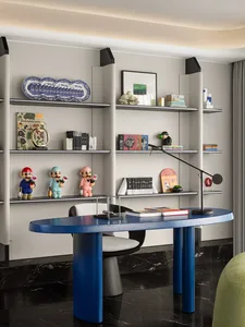 A minimalist home office featuring a blue desk and marble shelving with various decorative items and books.