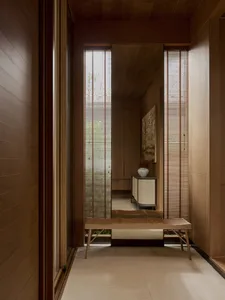 Modern corridor with wooden cabinets, blinds, and a bench seat.