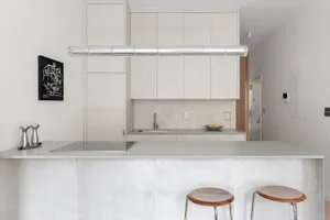 A modern kitchen featuring a concrete countertop and minimalist design.