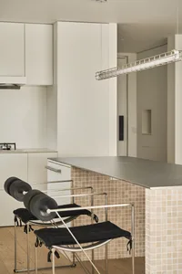 A modern kitchen with a concrete countertop and minimalist design elements.