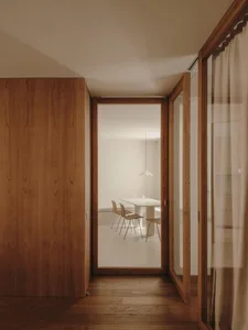 Modern minimalist dining room with wooden floors and furniture.