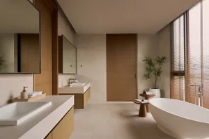 Modern bathroom with wooden doors, stone sink, and concrete floor and tub.