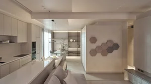 Modern living, dining, and kitchen space with concrete cabinets, minimalist design, and open layout