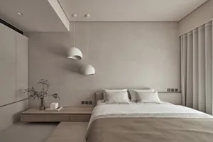 A minimalist bedroom with neutral tones and white pendant lights.