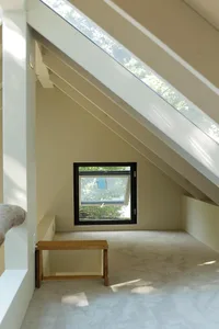 A minimalist bedroom featuring wooden furniture, carpet flooring, and large windows with glass.