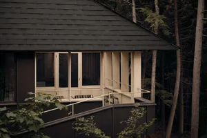 A minimalist residential porch with wooden elements and railing.