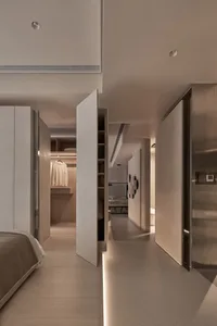 A modern bedroom with a closet featuring neutral-toned materials and minimalist design.