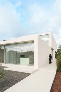 A modern house with a white minimalist design and concrete features.