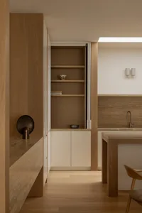 A modern minimalist kitchen featuring wood elements and a clean design.