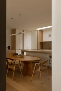 Modern minimalist living dining room featuring wooden furniture and stone countertops.